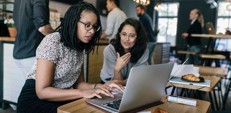 Dos mujeres frente laptop